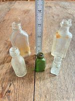 Front view of five miniature bottles with ruler for scale