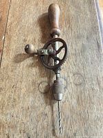 Side view of hand drill showing gear mechanism, crank and installed bit