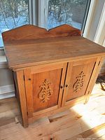 Front angled view showing entire cabinet, carved doors, backsplash