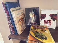 Group of books standing upright and leaning, showing spines and covers