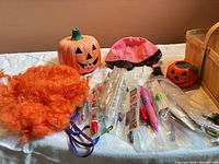 Group shot of entire lot on table: wig, candle holders, pens, stickers