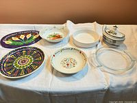 Seven serving pieces arranged on tablecloth