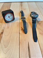 All three items front view: Casio digital watch, TIME analog watch, Cosmo alarm clock