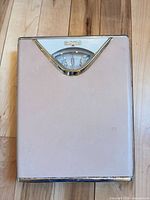 Top view showing pink surface, chrome bezel and dial