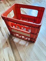 Overall view of red-orange plastic crate showing branding and compartments