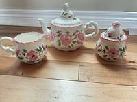 Full view of ceramic teapot, creamer and sugar bowl showing pattern and form