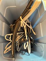 Hangers piled in a bin showing white and black pieces, metal hooks visible