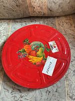 Top of red Kodak film canister showing fruit decal and Fragile sticker