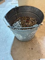 Overall view of galvanized bucket containing nails