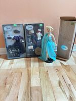 Group shot of doll, two boxed outfits, outer box