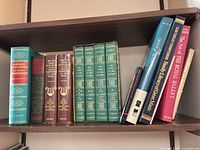 Shelf view showing Bartlett’s Familiar Quotations, Milton Cross volumes, The Lives of the Painters set, ballet books and others