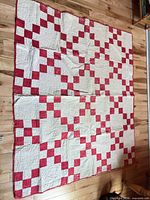Full view of red and white Irish Chain quilt laid flat