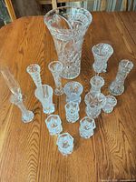 All fourteen clear crystal vases displayed on tabletop