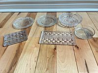 All six clear pressed and cut glass pieces laid out on floor