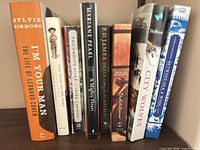 All nine books standing shoulder to shoulder showing spines