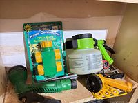 Group shot showing connector package, green spray nozzle, hose-end sprayer, yellow nozzle, metal parts
