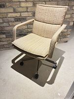 Front view of beige striped fabric office chair showing seat, backrest, arms and metal base