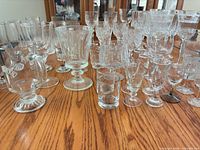Assorted clear glassware spread on table showing variety of sizes and shapes