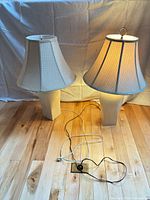 Both table lamps with shades, one illuminated, cords visible