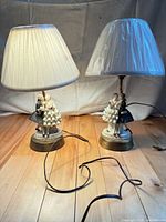 Both porcelain figurine lamps with shades and cords visible