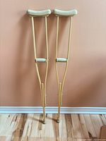 Full view of both wooden crutches standing upright