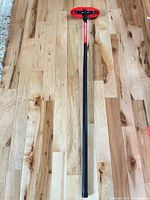 Full length view of curling broom on wood floor