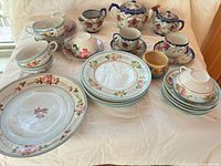 Overview of entire lot showing teapot, sugar bowl, cups, saucers, plates, bowl