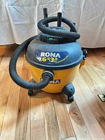 Front view of RONA wet/dry vacuum with hose attached