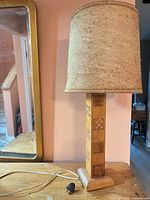 Front view of lamp with shade showing base, cord, plug and table for scale