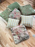 All seven pillows spread on wood floor