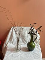 Both vases with faux stems displayed on white cloth