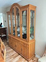 full view of oak china cabinet showing upper glass display and lower storage