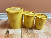 Front view of three yellow Tupperware canisters with lids