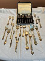 Full lot view showing assorted forks and fitted case