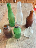 overview showing six glass bottles in assorted colors and shapes