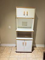 Front view of cabinet showing closed doors and open shelf