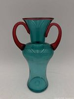Front view of teal blue vase with burgundy handles and rim