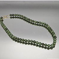 Full view of entire beaded necklace laid out in oval shape