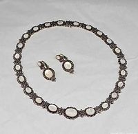 Necklace arranged in circle with both earrings displayed inside