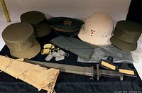 Group shot of all military items including sword, caps, helmet, dog tags and patches