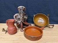 Group shot of sculpture, pitcher, hanging bowl, shallow pan