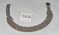 Full view of silver mesh choker necklace laid flat