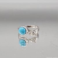 Full view of sterling silver adjustable ring with turquoise cabochon and pear clear stone