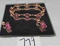 Bracelet and earrings set displayed on black surface