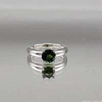 Full view of sterling silver ring with green gemstone facing forward