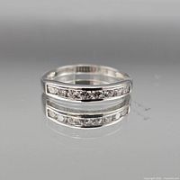 Front view of sterling silver channel-set diamond band ring showing row of diamonds