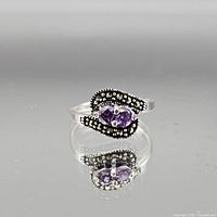 Top view of sterling silver ring showing purple gemstone and accent stones