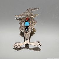 Front view of sterling silver animal brooch showing cabochon stones and overall form
