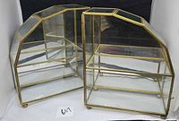 Two brass and glass display cases front view showing shape and interior shelves