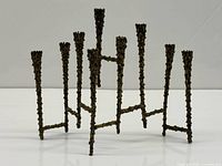 Front view of brass seven-arm candleholder showing full structure and texture